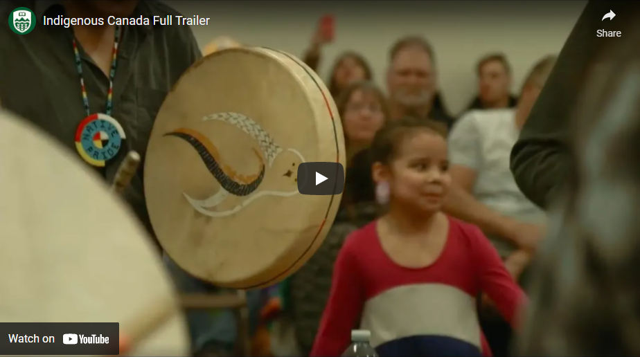 Indigenous person holding traditional hand drum